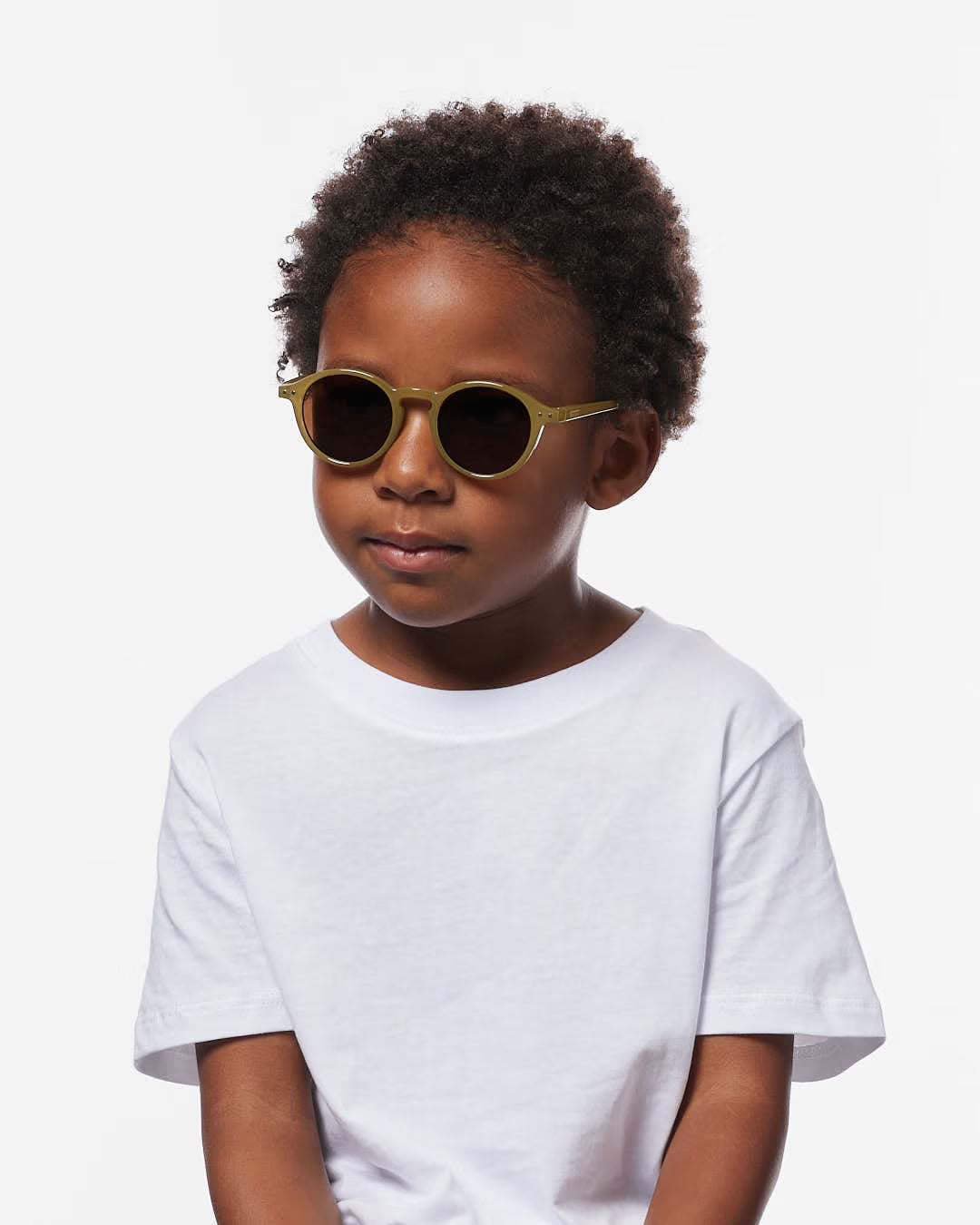 Children's olive-colored IZIPIZI sunglasses for ages 3-5, stylish and protective eyewear in a natural outdoor setting.