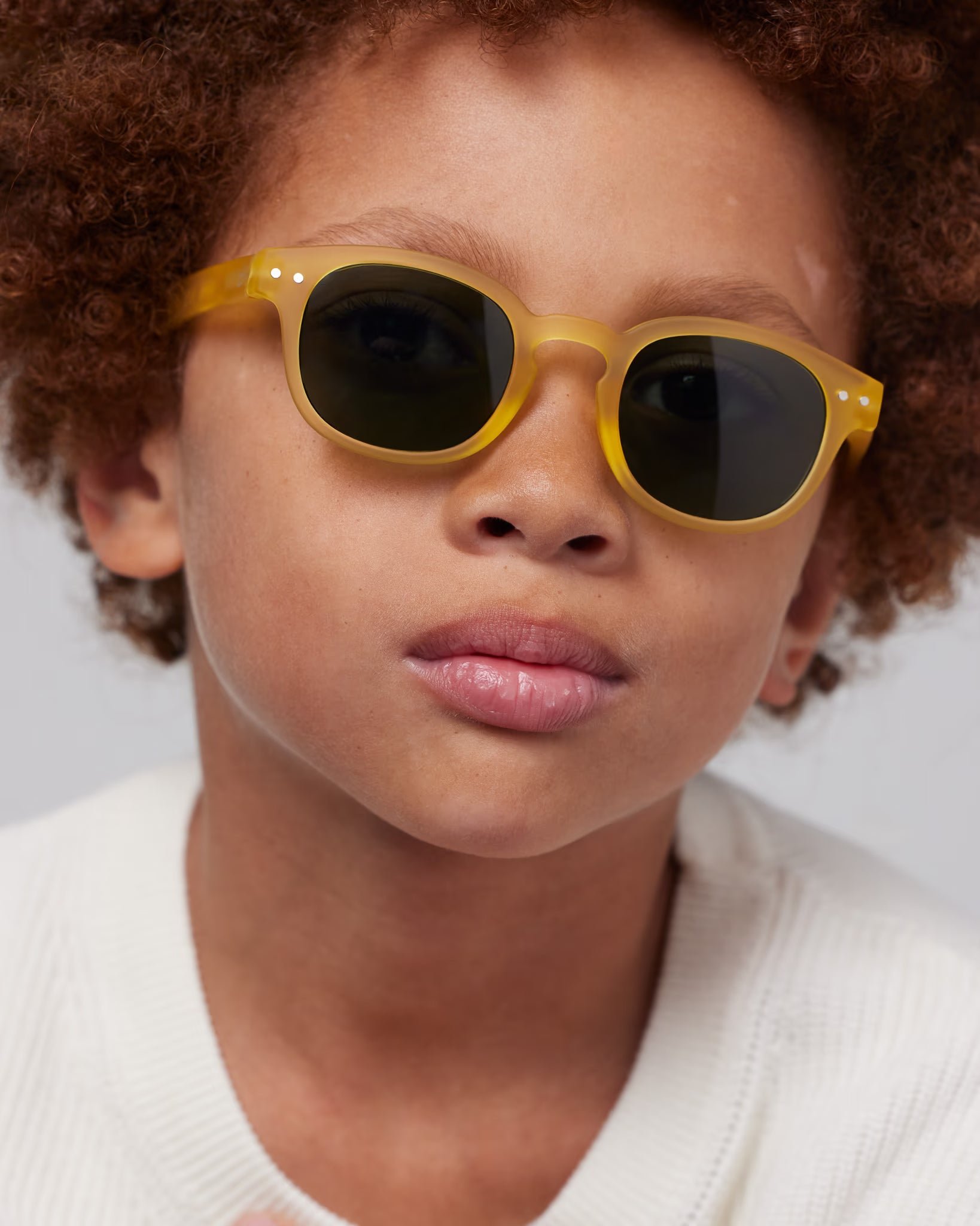 Children's yellow honey sunglasses by IZIPIZI, stylish mode eyewear for kids aged 5-7, with vibrant yellow frames.